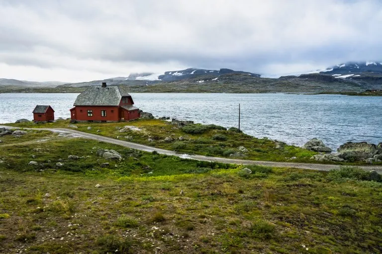 An isolated house on a lake in Hardangervidda National Park near Finse, Norway. Photo taken from Oslo-Bergen train, one of the most spectacular European railways